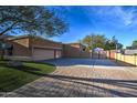 Expansive driveway with a basketball hoop that leads to a three-car garage and secure gated area at 5332 W Misty Willow Ln, Glendale, AZ 85310