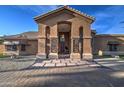 Grand entrance showcasing an arched entryway, tiled walkway, and a striking wooden front door at 5332 W Misty Willow Ln, Glendale, AZ 85310