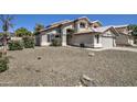 Inviting two-story home with a gravel yard, complemented by mature bushes, for a serene and stylish curb appeal at 5618 W Blackhawk Dr, Glendale, AZ 85308