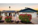 Charming home exterior featuring solar panels, a well-maintained yard with vibrant bushes, and a welcoming entryway at 624 E Laguna Dr, Tempe, AZ 85282