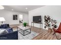 Open living area with hardwood flooring, large TV, comfortable seating, and access to other rooms at 624 E Laguna Dr, Tempe, AZ 85282