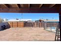 Expansive backyard area featuring a wooden fence, dirt landscaping, and a covered patio structure at 7136 W Lewis Ave, Phoenix, AZ 85035