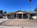 Single-story home with a covered front porch, desert landscaping, and a welcoming entrance at 7136 W Lewis Ave, Phoenix, AZ 85035