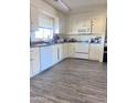 Bright kitchen featuring white cabinetry, ample counter space, and modern appliances set on wood-look floors at 7136 W Lewis Ave, Phoenix, AZ 85035