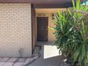 Close-up of the front door showcasing its unique design and the surrounding desert-style landscaping at 12639 N 113Th Dr, Youngtown, AZ 85363