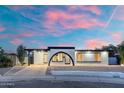 Attractive single-story house boasting a unique arched entrance, covered carport, and desert-style landscaping at 1317 E Verlea Dr, Tempe, AZ 85282