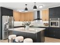 Modern kitchen featuring black and wood cabinetry, stainless steel appliances, and a spacious center island at 1317 E Verlea Dr, Tempe, AZ 85282