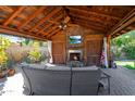 Covered outdoor living area with stone fireplace, comfortable seating, and mounted flat screen TV at 14821 N Hana Maui Dr, Phoenix, AZ 85022