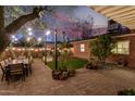 Inviting backyard with patio, dining area under string lights, and manicured lawn, ideal for outdoor gatherings at 1513 W Mitchell Dr, Phoenix, AZ 85015