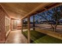 Covered porch area overlooking the yard with faux grass and desert landscaping at 1513 W Mitchell Dr, Phoenix, AZ 85015