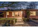 Cozy brick home featuring desert landscaping, stepping stones, and covered porch with a lawn at 1513 W Mitchell Dr, Phoenix, AZ 85015