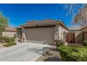 Side view of a single-story home with a two-car garage and desert landscaping at 17784 W Sandy Rd, Goodyear, AZ 85338