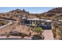 Desert home boasting a modern architectural design, surrounded by rugged terrain and natural vegetation at 1805 E Rocky Slope Dr, Phoenix, AZ 85048