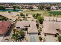 Overhead shot of property showcasing tile roof and community features including golf course and lake at 18514 N Laguna Azul Ct, Surprise, AZ 85374