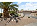 Home with xeriscaping, featuring a two-car garage and desert plants at 18514 N Laguna Azul Ct, Surprise, AZ 85374
