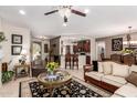 Open living room with a bar and kitchen featuring tile flooring and stylish décor at 18867 N Cactus Flower Way, Surprise, AZ 85387