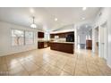 Spacious kitchen with dark wood cabinets, tile flooring and breakfast bar perfect for entertaining at 20838 N 39Th Dr, Glendale, AZ 85308