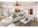 Bright open concept living room with dining area and kitchen featuring neutral decor and tile floors at 22236 N Arrellaga Dr, Sun City West, AZ 85375
