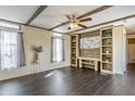 Open-concept living room with decorative beams and a built-in entertainment center with shelves at 255 S 92Nd Pl, Mesa, AZ 85208