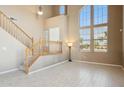 Bright living room with soaring ceilings, large windows, staircase and tile flooring at 44390 W Buckhorn Trl, Maricopa, AZ 85138