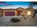 Charming single-story home featuring a two-car garage, desert landscaping, and a welcoming entrance at 5318 W Grenadine Rd, Laveen, AZ 85339