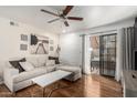 Bright living room with wood floors, neutral palette, ceiling fan, and balcony access at 533 W Guadalupe Rd # 1001, Mesa, AZ 85210