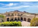Elegant two-story home boasts a tile roof, three-car garage, and lush landscaping, set against a mountain backdrop at 7046 N 59Th Pl, Paradise Valley, AZ 85253