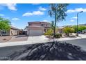 Two-story home with a three car garage, desert landscaping, and a tile roof set against a blue sky at 8817 S 13Th Way, Phoenix, AZ 85042