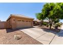 Single-story home with a two-car garage, xeriscaped yard, and a long driveway under a clear blue sky at 9511 E Kiva Ave, Mesa, AZ 85209