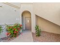 Close up of a unit entrance with neutral paint, decorative plants, and an inviting, covered entry way at 9555 E Raintree Dr # 1018, Scottsdale, AZ 85260