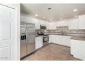 Bright kitchen featuring stainless steel appliances, white cabinetry, tiled backsplash, and sleek countertops at 9555 E Raintree Dr # 1018, Scottsdale, AZ 85260