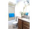 A clean and bright bathroom features a wood vanity, a framed glass shower, and modern fixtures at 11012 W Caron Dr, Sun City, AZ 85351