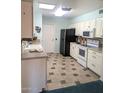 A charming kitchen is equipped with white cabinets, sleek appliances, and a tiled floor at 11012 W Caron Dr, Sun City, AZ 85351