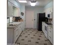 A well-lit kitchen is equipped with white cabinets, sleek appliances, and a tiled floor at 11012 W Caron Dr, Sun City, AZ 85351