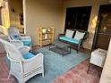 Relaxing covered patio with wicker furniture set upon a decorative area rug at 14300 W Bell Rd # 58, Surprise, AZ 85374