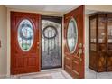 Elegant entryway with decorative double doors featuring beveled glass in oval shapes and a wrought iron design at 25850 S Foxglenn Dr, Sun Lakes, AZ 85248