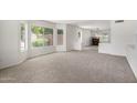 Bright living room with neutral carpet, ample natural light, and open layout at 26066 N 72Nd Ave, Peoria, AZ 85383