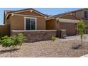View of the front of this single story home highlighting the desert landscaping at 40835 W Agave Rd, Maricopa, AZ 85138
