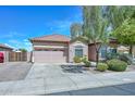 Single-story home with a 2-car garage and meticulously landscaped front yard and walkway at 4306 W Summerside Rd, Laveen, AZ 85339