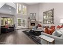 Spacious living room with high ceilings, a cozy fireplace, hardwood floors, and lots of natural light at 8424 E San Bernardo Dr, Scottsdale, AZ 85258