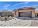 A well-maintained garage with a brown door, complemented by low-maintenance desert landscaping and a clean driveway at 903 W Raven Dr, Chandler, AZ 85286