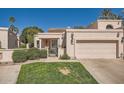 Charming single-story home featuring a two-car garage, well-manicured lawn, and desert landscaping at 10062 E Cinnabar Ave, Scottsdale, AZ 85258