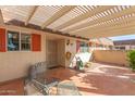 Charming covered front porch with tiled floor and seating, perfect for relaxing outdoors at 10425 W Desert Forest Cir, Sun City, AZ 85351