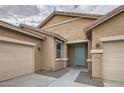 Inviting single-story home with a blue door and trim, a well-maintained lawn and a two-car garage at 10528 W Crown King Rd, Tolleson, AZ 85353