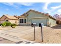 Charming single-story home featuring a well-manicured front yard and a two-car garage at 1347 E Vernoa St, San Tan Valley, AZ 85140