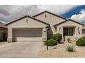 Charming one-story home features a neutral stucco exterior and a two-car garage at 15885 W Remington Dr, Surprise, AZ 85374