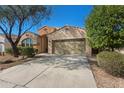 Inviting home with a two-car garage, desert landscaping, a large driveway, and lush desert trees at 18222 E La Posada Ct, Gold Canyon, AZ 85118