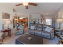 Open-concept living room with a ceiling fan, comfortable seating, and access to the kitchen at 19615 N Sunburst Way, Surprise, AZ 85374