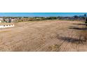 Expansive field ready for development, showcasing potential with distant horizon and clear skies at 20521 E Germann Rd, Queen Creek, AZ 85142