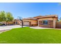 A well-manicured house with grass, stone accents and a driveway leading to attached garage at 20540 N 86Th Ln, Peoria, AZ 85382